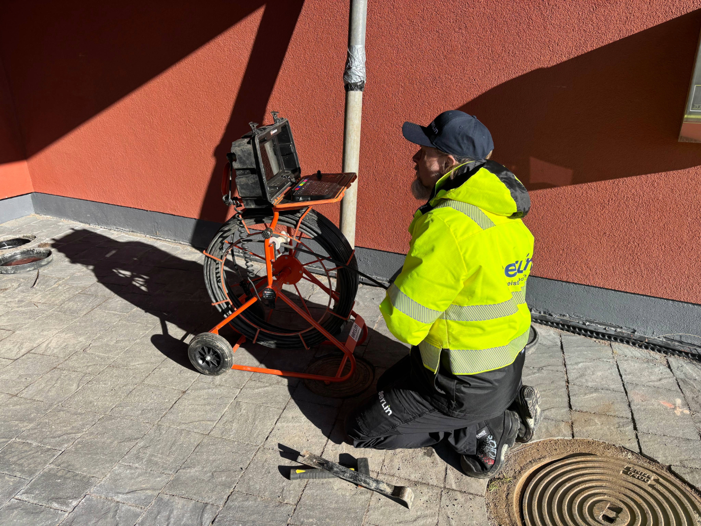 Jani kuvaamassa salaojia taloyhtiön pihalla.