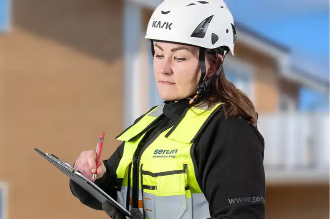 Mira täyttämässä taloyhtiön huoltoraporttia.