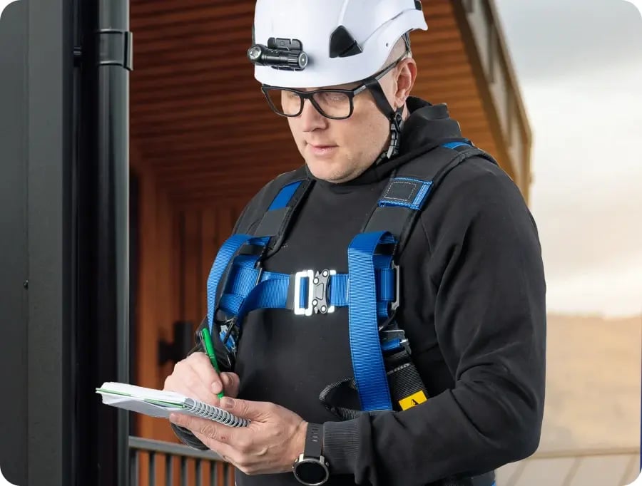 Juha laatimassa muistiinpanoja taloyhtiön huoltotarkastuksessa.