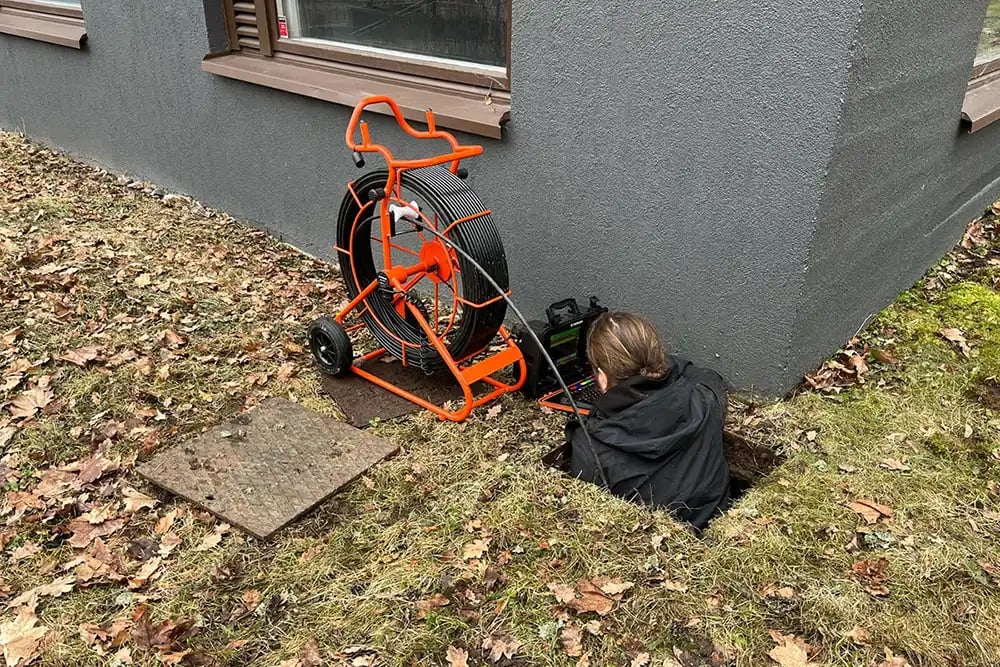 Janne suorittamassa omakotitalon salaojien tarkastusta ja kuvausta.