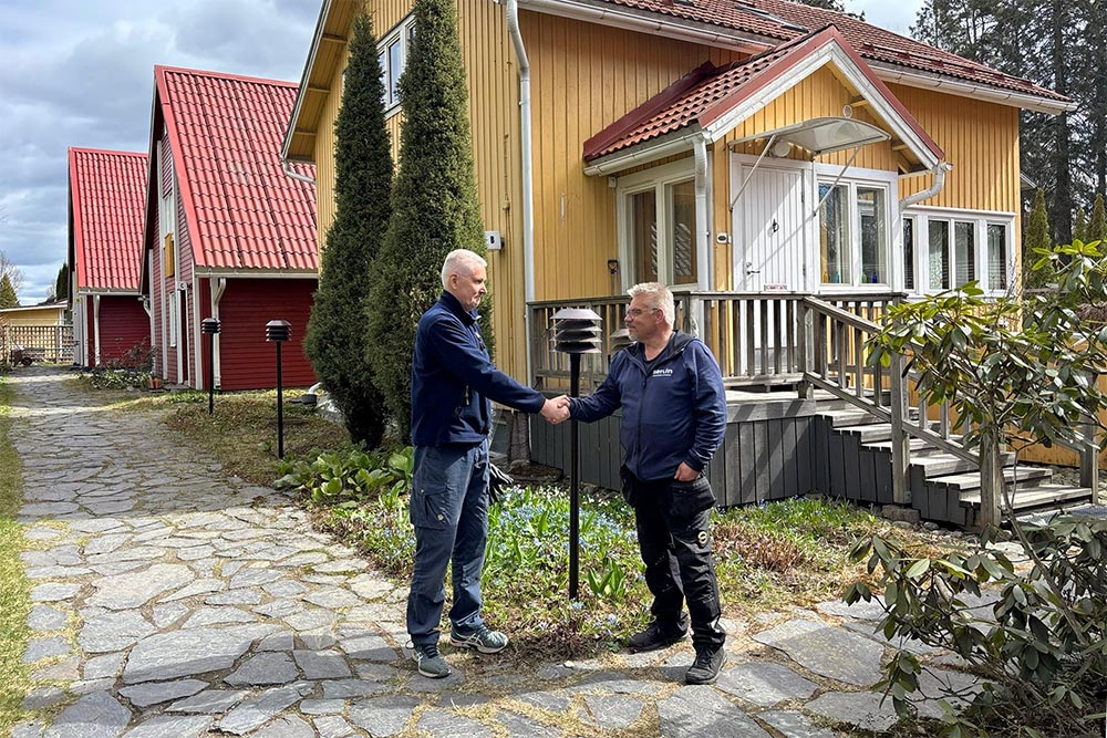 Asukas Jouko Muurinen ja Serlinin kattoasiantuntija kättelevät onnistuneen katon turvakunnostuksen jälkeen.